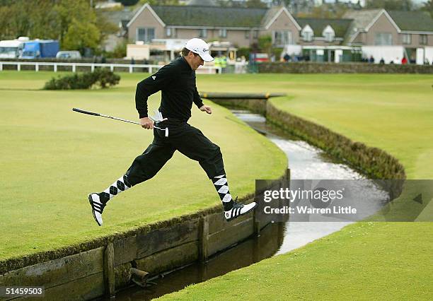 Ian Poulter of England jumps over the Swilken burn on the first during the final round of the Dunhill Links Championship at St Andrews Golf Club on...