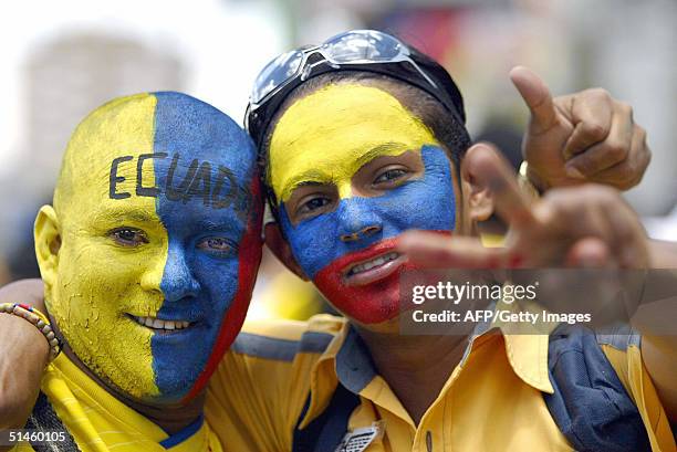 Hinchas ecuatorianos con sus caras pintadas con los colores de su seleccion hacen signos de victoriaantes de ingresar al estadio Olimpico Atahualpa,...