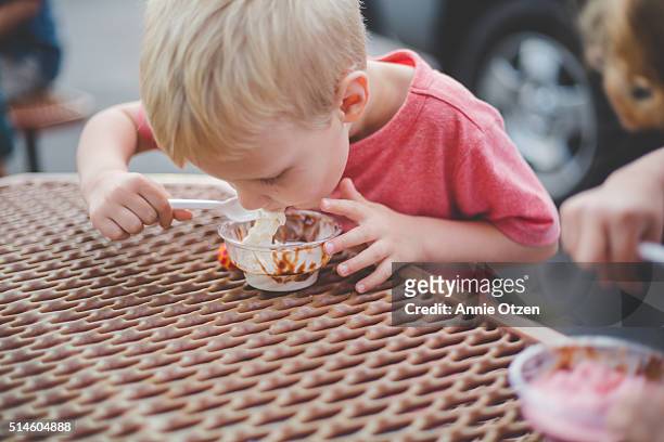 boy eating ice cream - filet de caramel photos et images de collection