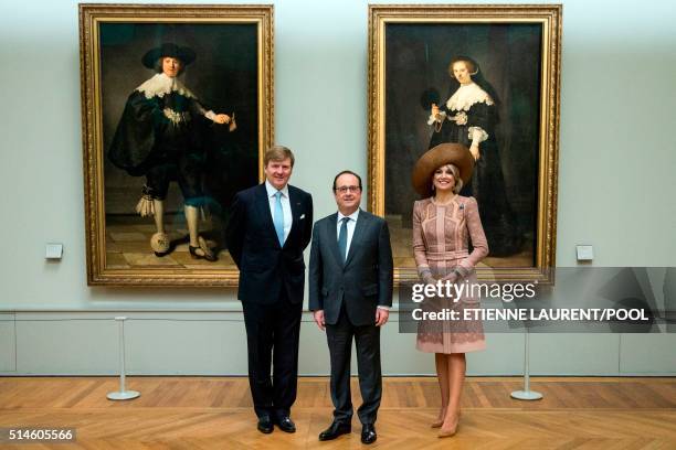 French President Francois Hollande poses with King Willem-Alexander and Queen Maxima of the Netherlands in front of two full-length wedding portraits...