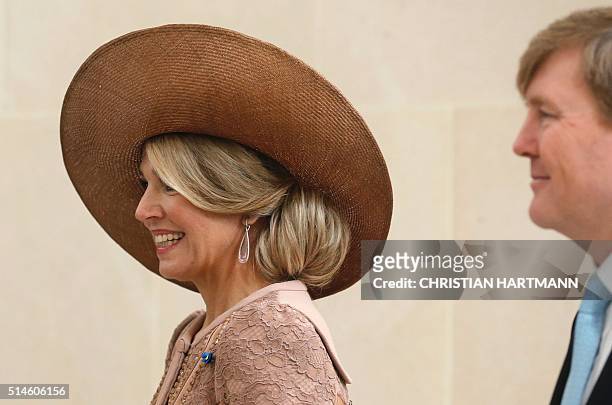 King Willem Alexander and Queen Maxima of the Netherlands react after signing the visitor's book at the Louvre Museum on March 10, 2016 as part of...