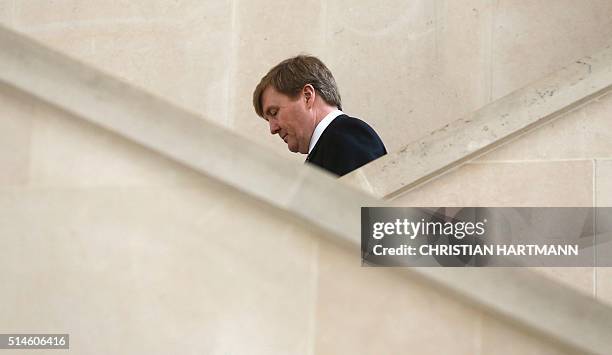 King Willem Alexander of the Netherlands walks down stairs after a visit to the Louvre Museum on March 10, 2016 as part of the acquisition of two...