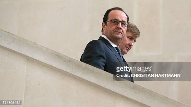 French President Francois Hollande and King Willem Alexander of the Netherlands walk down stairs after a visit to the Louvre Museum on March 10, 2016...