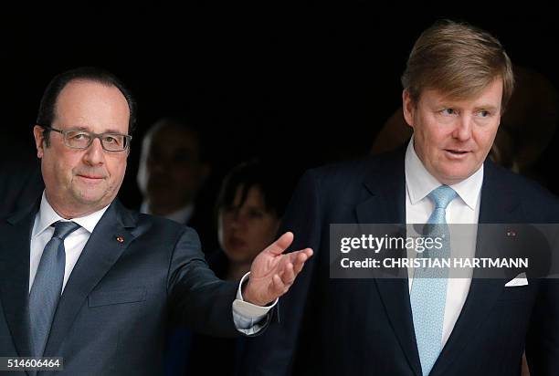 French President Francois Hollande , King Willem Alexander of the Netherlands arrive to sign the visitors' book at the Louvre Museum on March 10,...