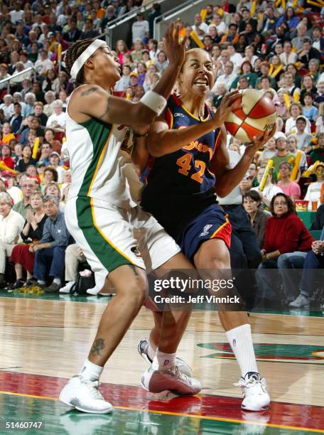 Nykesha Sales of the Connecticut Sun drives around Betty Lennox of the Seattle Storm during the first half in Game 2 of the WNBA Finals on October...