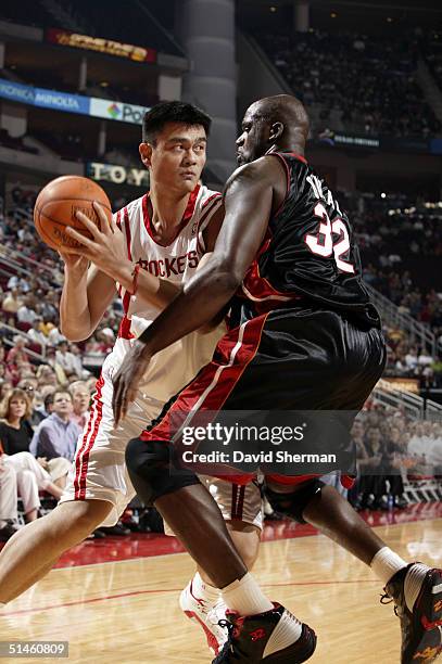 Yao Ming of the Houston Rockets is guarded by Shaquille O'Neal of the Miami Heat on October 10, 2004 at the Toyota Center in Houston, Texas. NOTE TO...