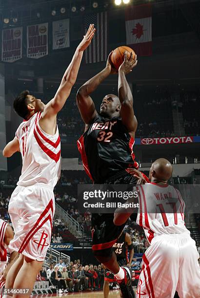 Shaquille O'Neal of the Miami Heat shoots over Yao Ming of the Houston Rockets on October 10, 2004 at the Toyota Center in Houston, Texas. NOTE TO...