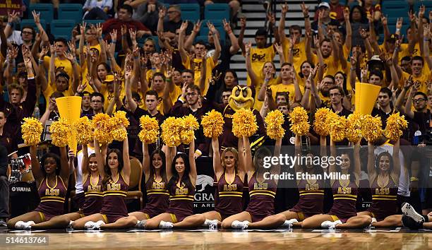 Arizona State Sun Devils cheerleaders and fans hold their arms up during a first-round game of the Pac-12 Basketball Tournament against the Oregon...
