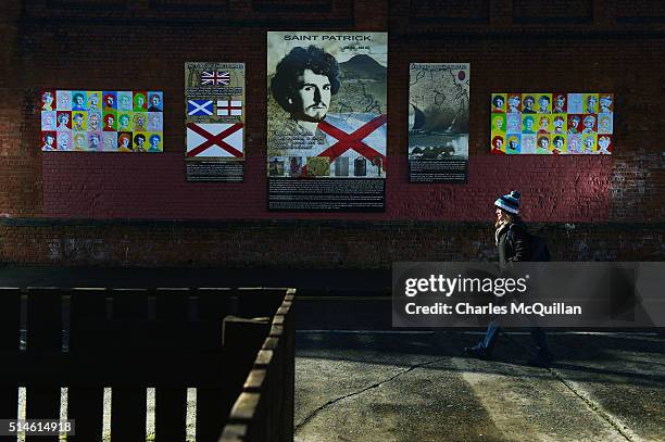 Young woman walks past a new mural of Saint Patrick in the loyalist village area on March 10, 2016 in Belfast, Northern Ireland. The mural was...
