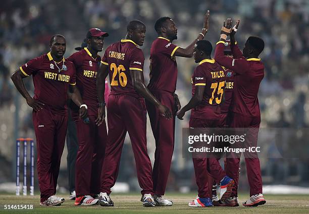 Sulieman Benn of the West Indies celebrate the wicket of Shikhar Dhawan of India with team mates during the ICC World Twenty20 warm up match between...