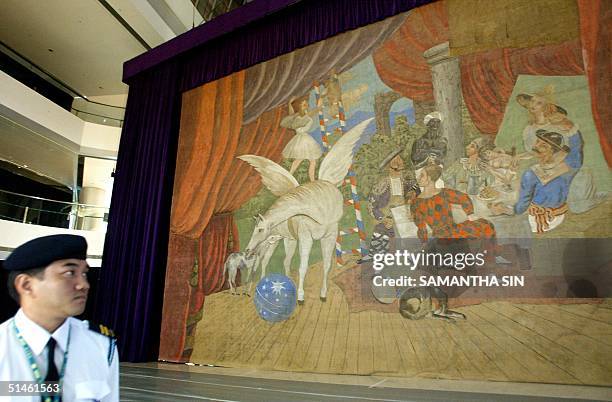 Security guard looks at one of Pablo Picasso's most famous work, the monumental stage curtain for the realist ballet "Parade" displayed at an Atrium...
