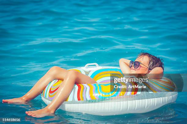 child in the sea - opblaasband stockfoto's en -beelden