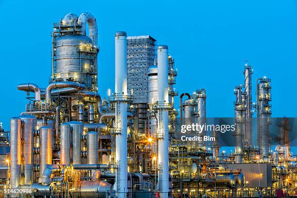 petrochemische fabrik beleuchtet bei dämmerung - kaminabend stock-fotos und bilder