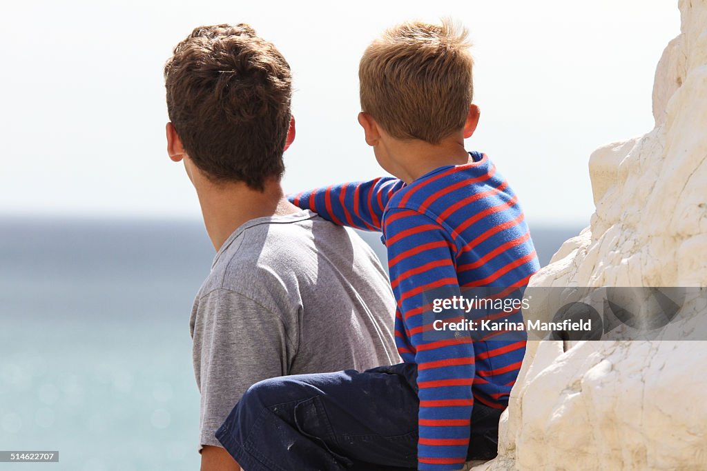 Two brothers looking towards the sea