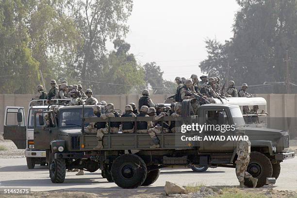 The Iraqi National Guard sit in trucks close to their base in Amiriyah on the western outskirts of Baghdad, 11 October 2004, following the release of...