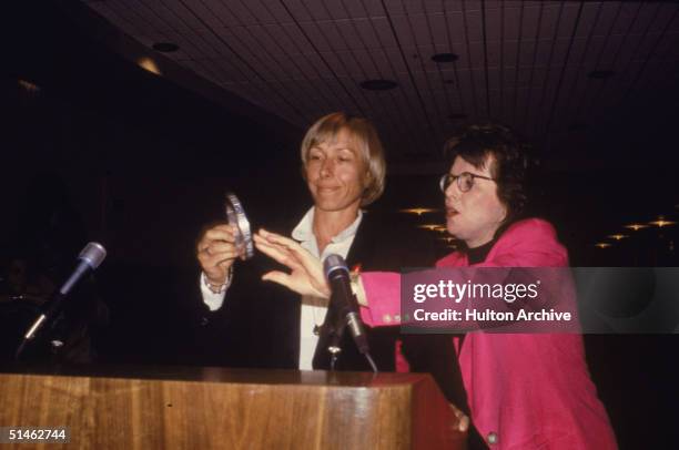 Czech-born American tennis player Martina Navratilova and American tennis great Billie Jean King stand at a podium and admire a metal object before a...