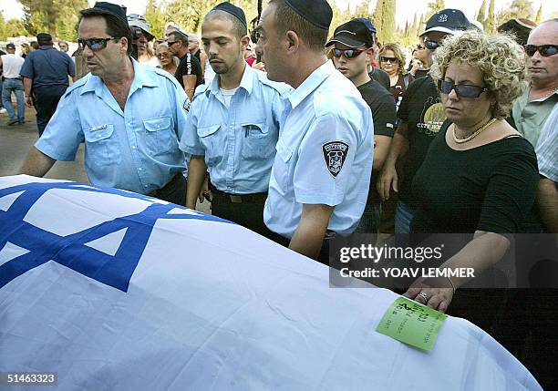 The mother of Israeli Assaf Greenveld touches his national flag-draped body 11 October 2004 during his funeral at a cemetery in Tel Aviv. Assaf was...