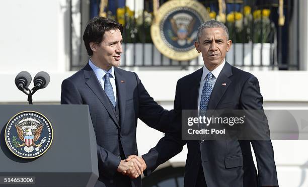 Canadian Prime Minister Justin Trudeau checks hands with President Barack Obama during a welcoming ceremony to the White House for an Official Visit...