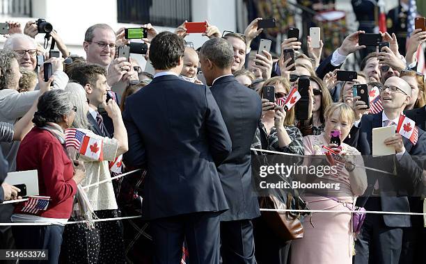 President Barack Obama, right, and Justin Trudeau, Canada's prime minister, greet an attendee's baby during a welcoming ceremony at the White House...