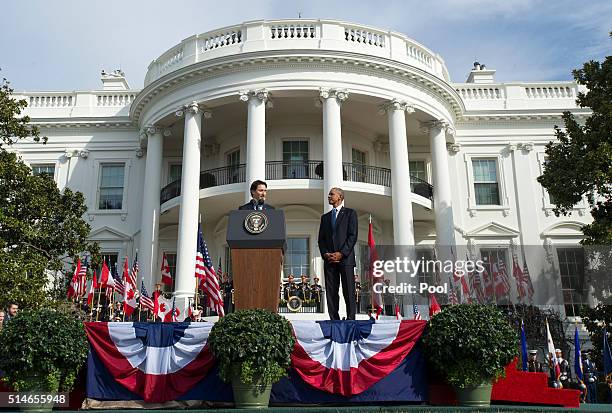 President Barack Obama listens as Canadian Prime Justin Trudeau delivers remarks during an arrival ceremony on the South Lawn of the White House, on...
