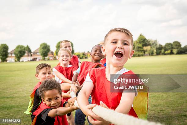 group of children playing tug of war - cabo fotografías e imágenes de stock