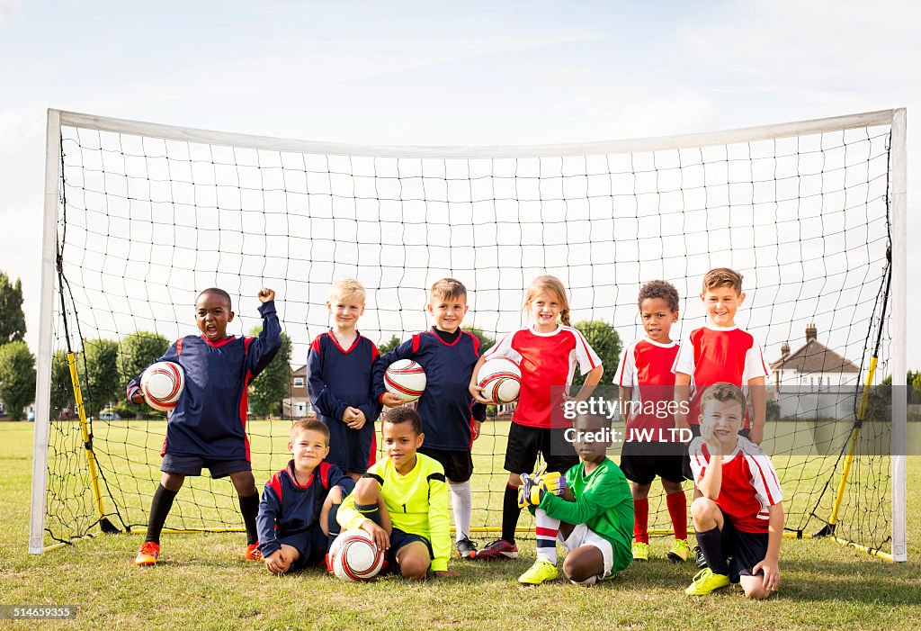 Ten children standing in football goal