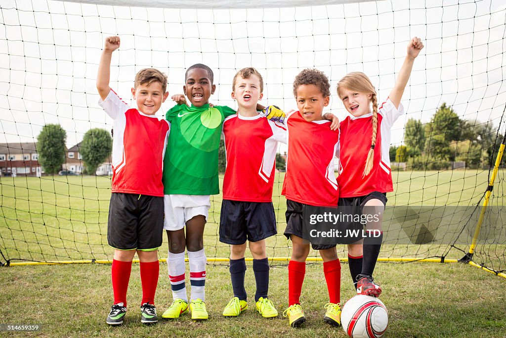 Five children standing in football goal