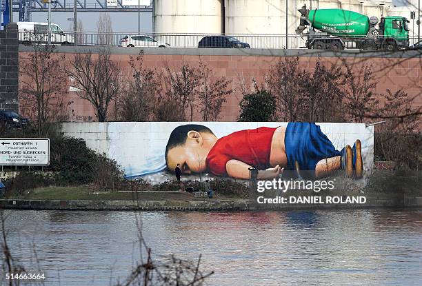 Graffiti by artists Justus Becker and Oguz Sen depicts the drowned Syrian refugee boy Alan Kurdi at the harbor in Frankfurt am Main, Germany, on...