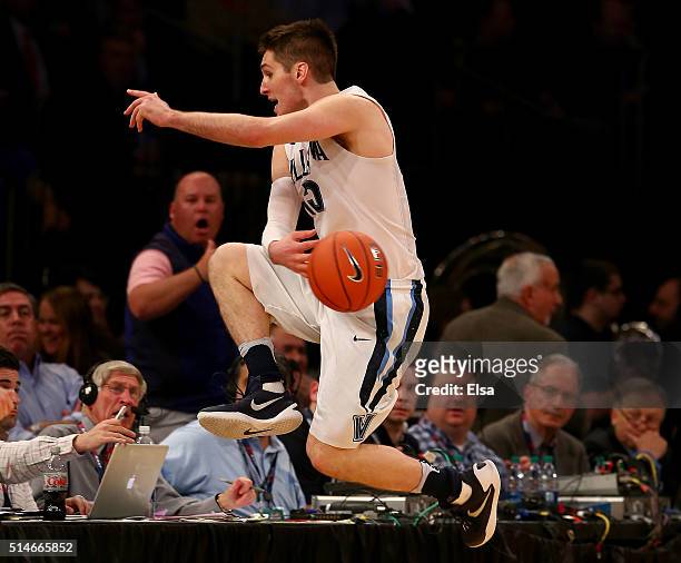 Ryan Arcidiacono of the Villanova Wildcats leaps into the front row as he keep the ball in play in the second half against the Georgetown Hoyas...