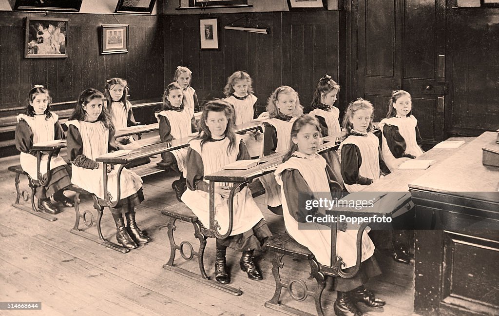 A vintage postcard featuring a classroom of young girl students in ...