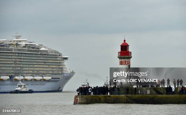 People look at the Harmony of the Seas cruise ship leaving the STX shipyard of Saint-Nazaire, western France, for a three-day test offshore, on March...