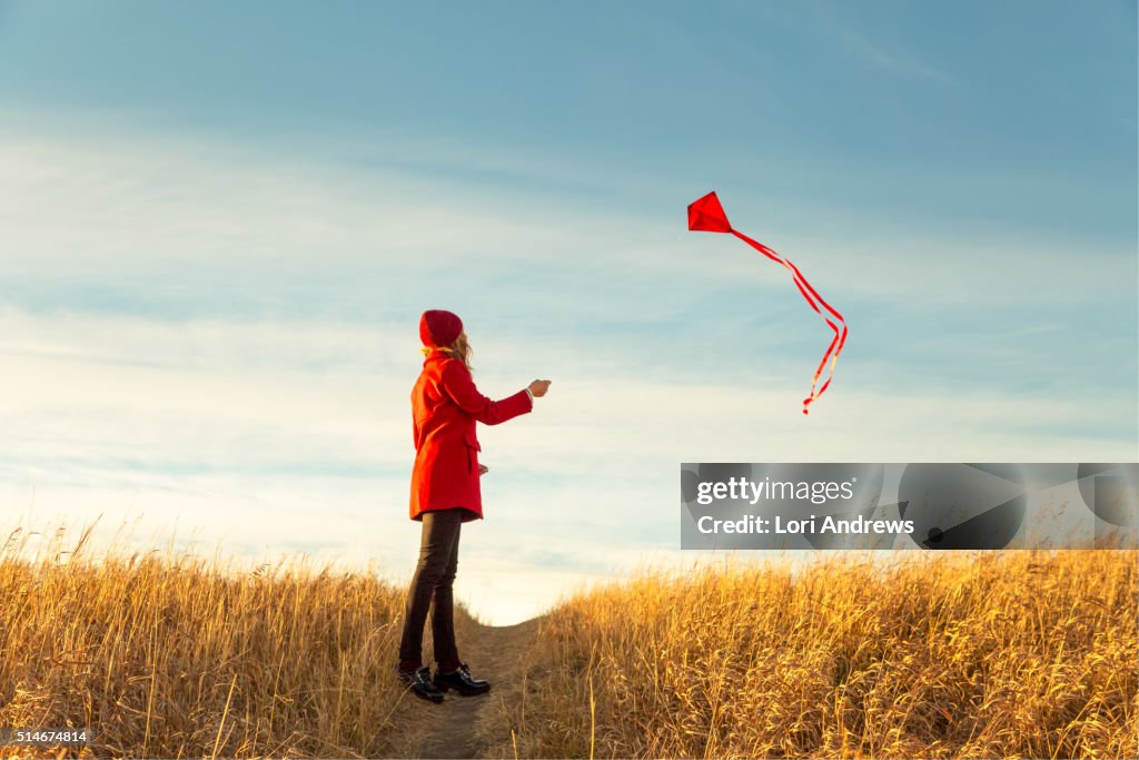 Woman flying kite in prairies