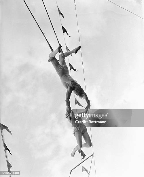 The Flying Royals at the peak of their trapeze act, completing what is known as a passing leap. Joe Seigrist and is about to catch Juanita Royal.