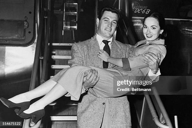 Petite screen star Ann Blyth gets service with a smile from film actor Rock Hudson as they alight from their airliner bringing them to New York from...