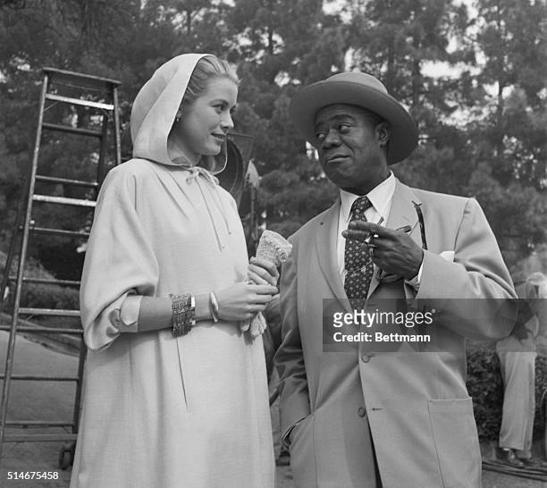 Hollywood, CA: Trumpet man Louis Armstrong, recently returned from an extensive tour of Europe, tells Grace Kelly about his trip during a break in...