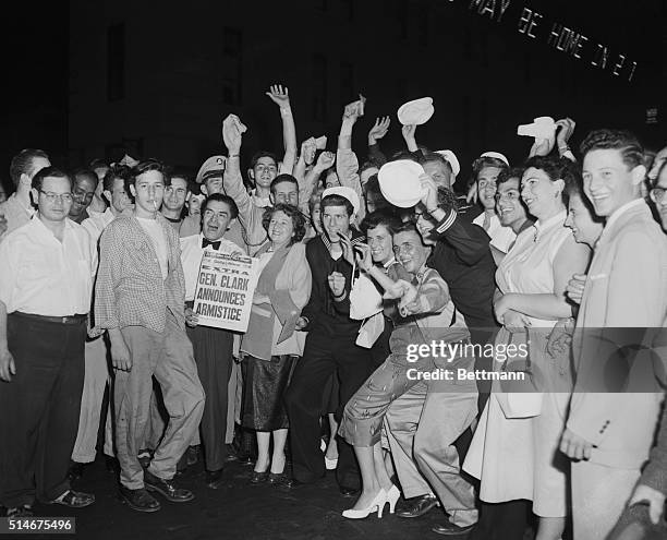 New York, NY: Celebrate truce. Servicemen join the celebration in Times Square as a group of New Yorkers cheer the news that a Korean Armistice has...