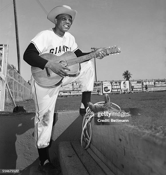 Phoenix, Arizona: New York Giants outfielder Willie Mays turns cowboy crooner on the steps of the dugout at Phoenix, complete with hat and guitar....