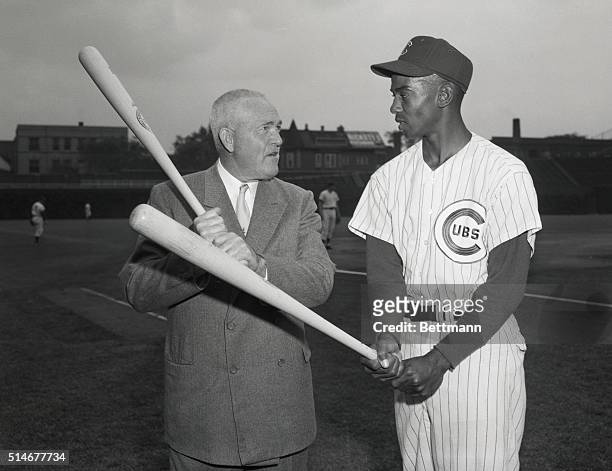 Chicago Cubs star shortstop Ernie Banks receives batting advice from Rogers Hornsby, one of baseball's great hitting stars and current batting coach...