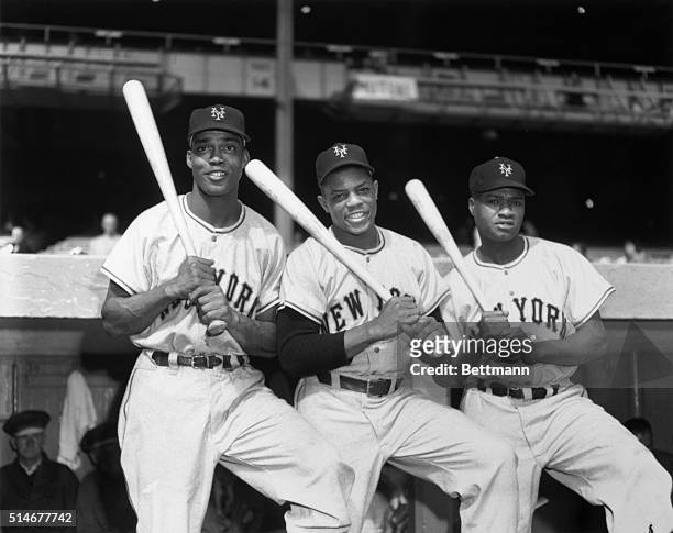 Monte Irvin , Willie Mays, and Hank Thompson hold bats on their shoulders in Yankee Stadium. All three men are playing with the New York Giants in...