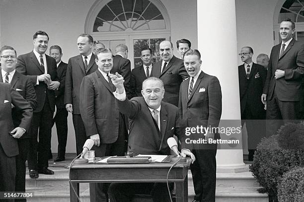 Washington, D.C.: President Johnson tosses out the last pen he used for the signing of the Appalachia bill during a White House ceremony. The pen was...