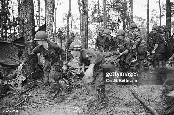 Shau Valley, South Vietnam: A quartet of U.S. 101st Air Division troopers keep low as they rush a stretcher-borne wounded comrade to a medical aid...