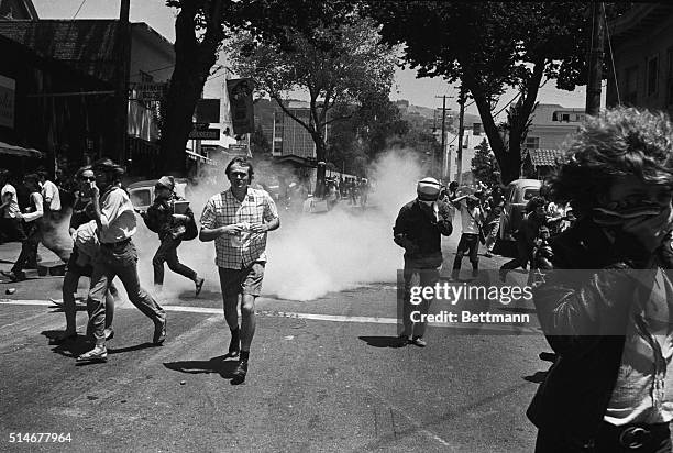 Demonstrators run from tear gas thrown at them by police after a new confrontation over People's Park.