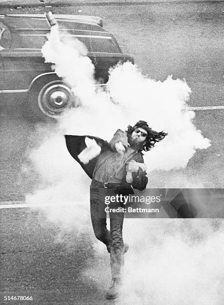 An anti-war demonstrator at the University of California, Berkeley throws a tear gas cannister at police during a student strike to protest the...