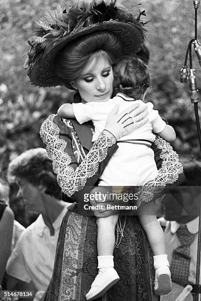 Barbra Streisand, in costume, comforts her son on the set of Hello Dolly