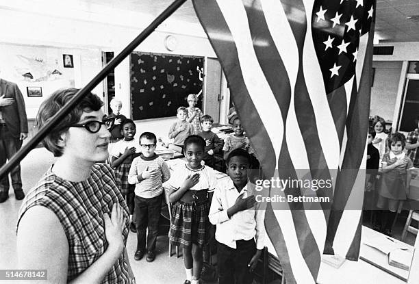 Cincinnati second grade teacher and her class pledge allegiance to the flag in their classroom. | Location: Near Cincinnati, Ohio, USA.