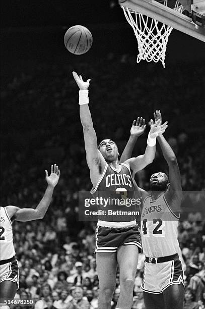Boston Celtic guard Dennis Johnson goes up for a shot as Los Angeles Laker forward James Worthy tries to defend him during 1st quarter action....