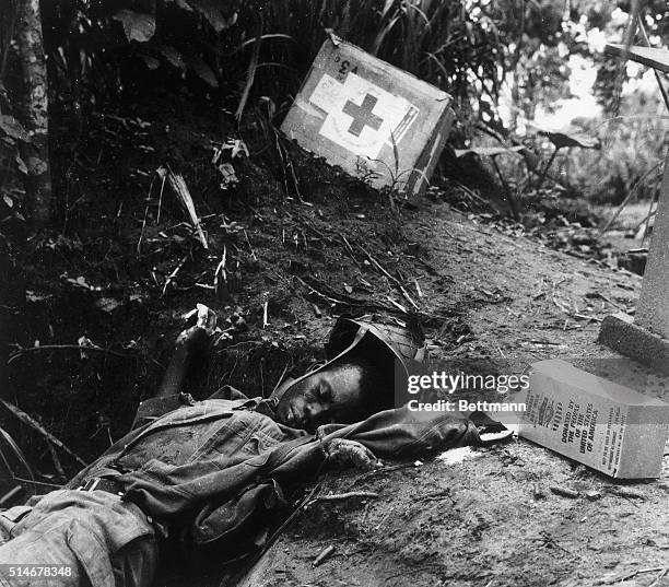 Dead Nigerian soldier found in his trench after the liberation of Ikot Ekpene in Biafra, clutching relief ration. 7/6/1968