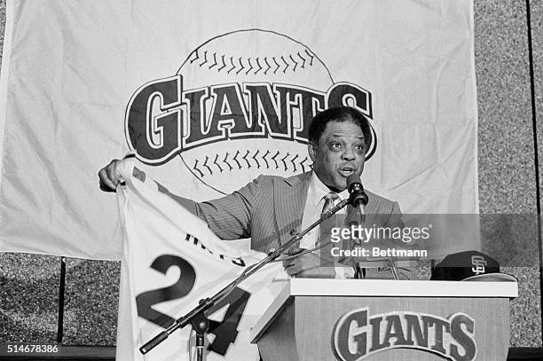 Former San Francisco Giants star outfielder Willie Mays holds up his jersey during a press conference in which it was announced that he was returning...