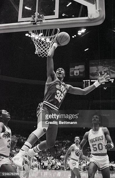 Utah Jazz forward Karl Malone drives in for a slam dunk in the first quarter as Houston Rockets Hakeem Olajuwon , Lewis Lloyd and Ralph Sampson look...