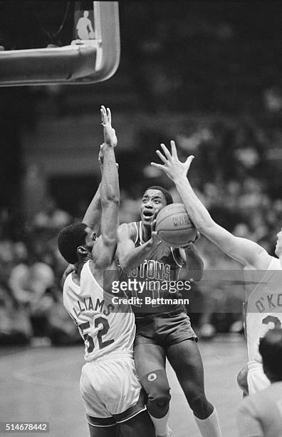 Detroit Piston Isiah Thomas attempts a shot over New Jersey Nets defender Buck Williams during the second quarter of a NBA basketball game. East...